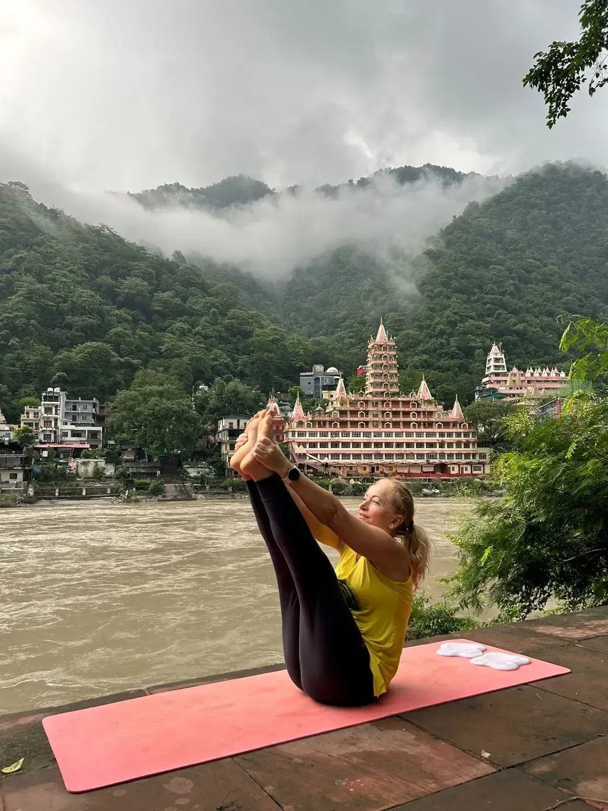 Eva practicing yoga beside the Ganges in Rishikesh, India